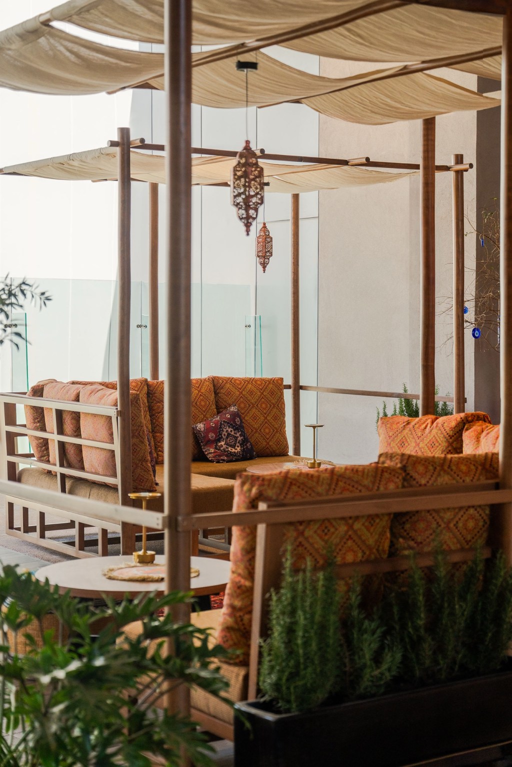 Terraza lounge con textiles y cabana de madera